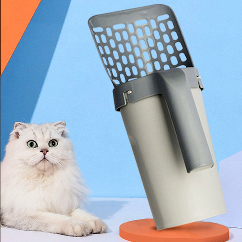 Cat litter scoop with built-in storage box standing upright beside a white cat