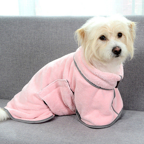 Terrier sitting on a sofa in the pink absorbent dog bathrobe with reflective piping
